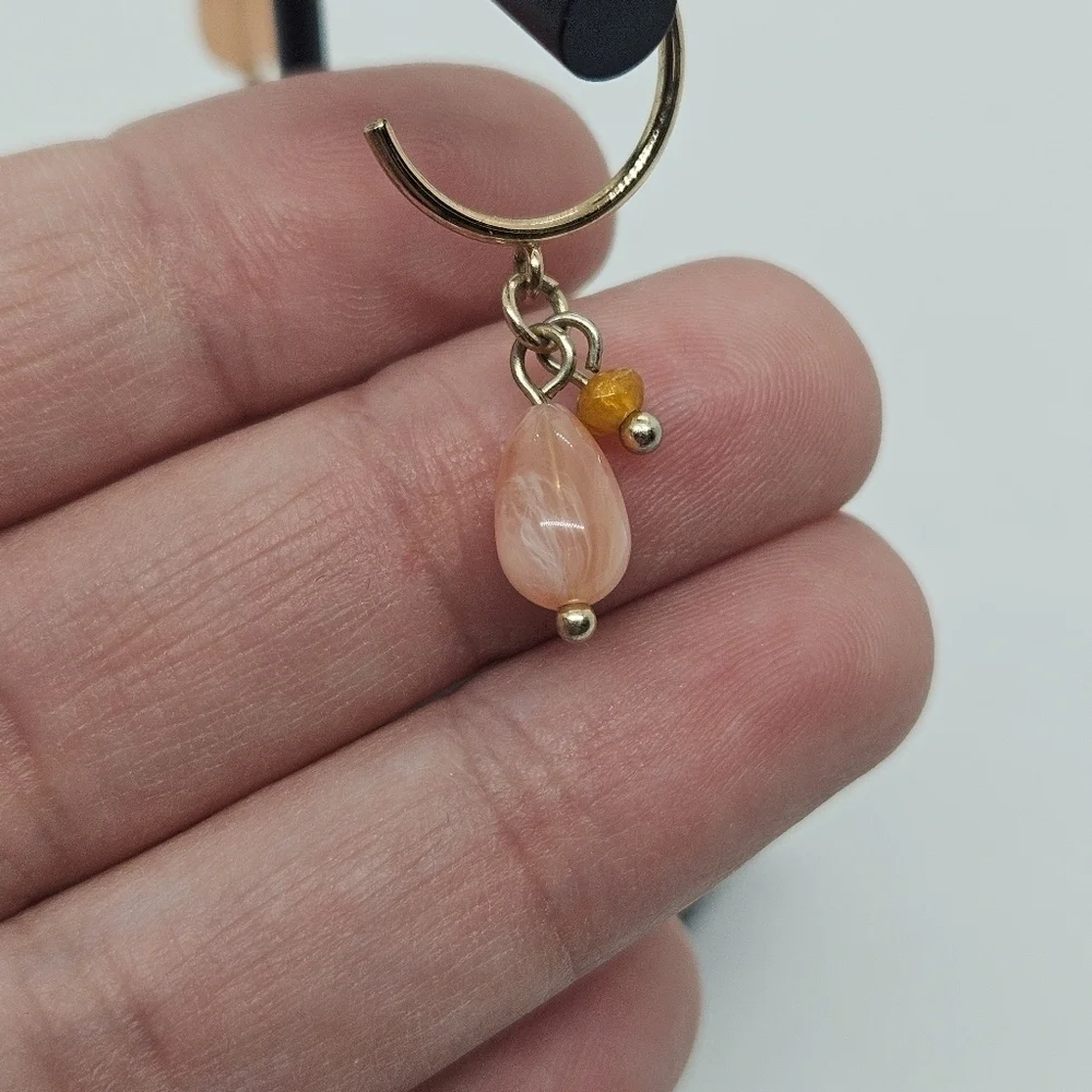 small gold tone hoop earrings with pink and orange beads